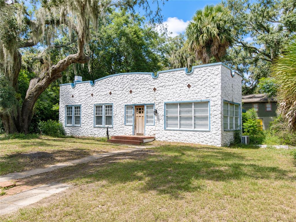 A single-story house with a textured white facade and a decorative parapet roofline — 208 W 17TH STREET, SANFORD, FL