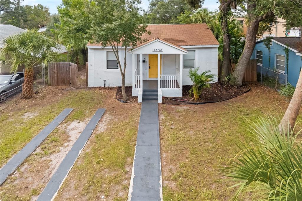 A white single-story house with a yellow front door and a small covered porch — 1636 PRESCOTT STREET S, ST PETERSBURG, FL