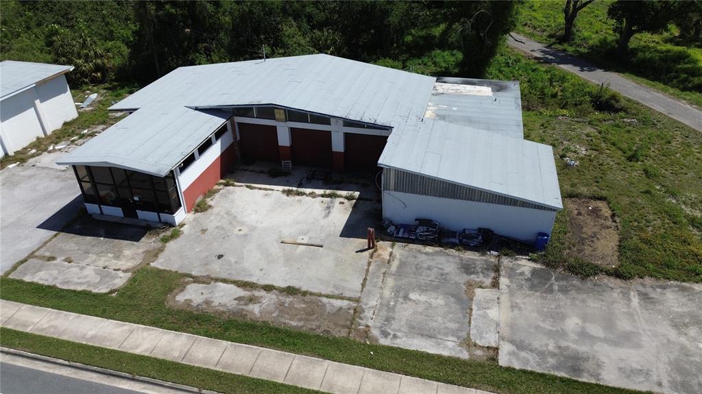 An aerial view shows a commercial building with a metal roof and a concrete lot — 4490 SW HIGHWAY 17, ARCADIA, FL