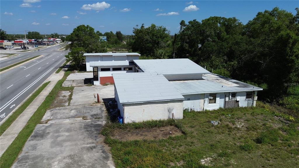 An aerial view shows a commercial building with a metal roof and paved parking area — 4490 SW HIGHWAY 17, ARCADIA, FL