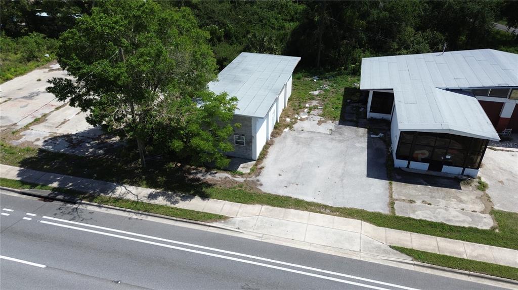 An aerial view shows two commercial buildings with metal roofs and adjacent concrete parking lots — 4490 SW HIGHWAY 17, ARCADIA, FL