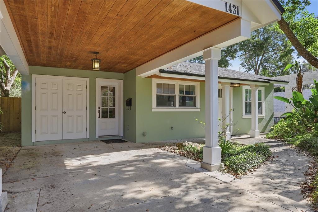 A light green house exterior features a covered carport with a wood-paneled ceiling — 1431 PALM AVENUE, WINTER PARK, FL