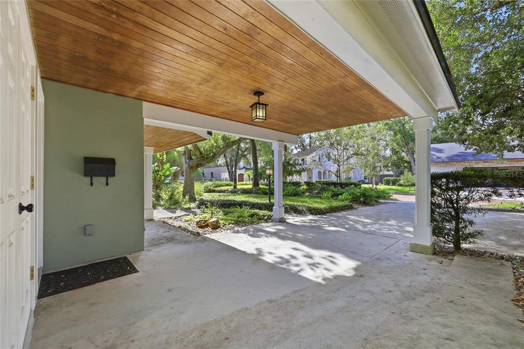 A covered concrete porch features a wood-paneled ceiling, a hanging lantern, and a green wall — 1431 PALM AVENUE, WINTER PARK, FL