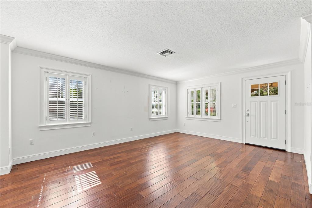 An empty room with white walls, plantation shutters, and dark wood flooring — 1431 PALM AVENUE, WINTER PARK, FL