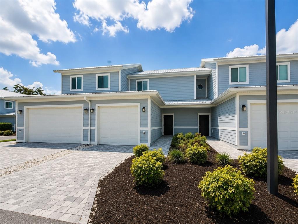 A two-story blue house with a paved driveway, a garage, and a landscaped front yard — 2414 WILLOW WAY, WINTER HAVEN, FL
