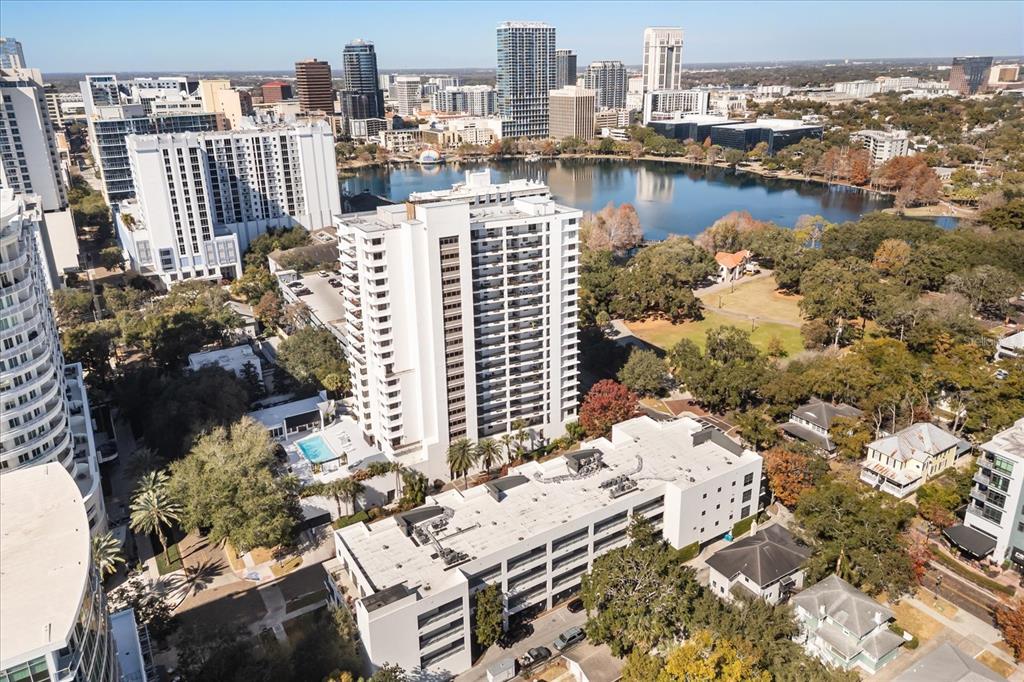 An aerial view shows a high-rise apartment building next to a lake and city skyline — 530 E CENTRAL BLVD UNIT 1901, ORLANDO, FL