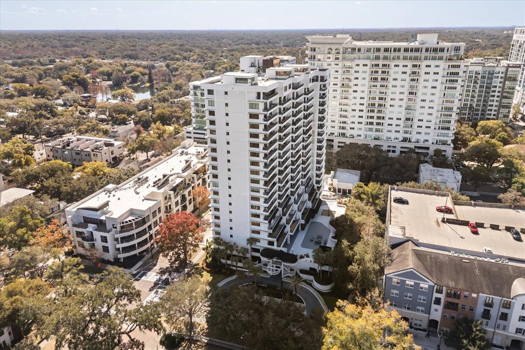 An aerial view shows a tall white apartment building surrounded by trees and other structures — 530 E CENTRAL BLVD UNIT 1901, ORLANDO, FL