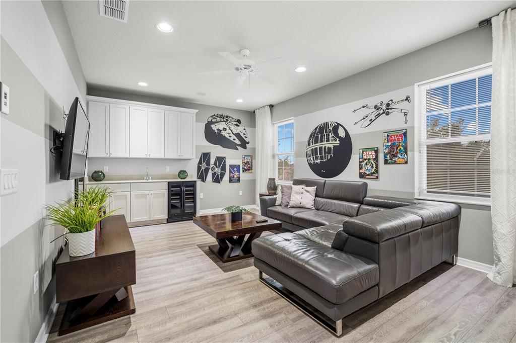 A Star Wars-themed living room features a grey sectional sofa, wet bar, and wall decals — 4007 OAKRISE LOOP, DAVENPORT, FL