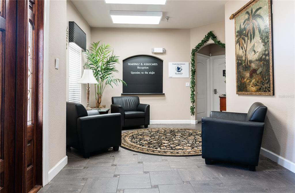 A waiting area features three black leather chairs, a circular rug, and a wall sign — 1100 TOWN PLAZA COURT UNIT 2010-F, WINTER SPRINGS, FL