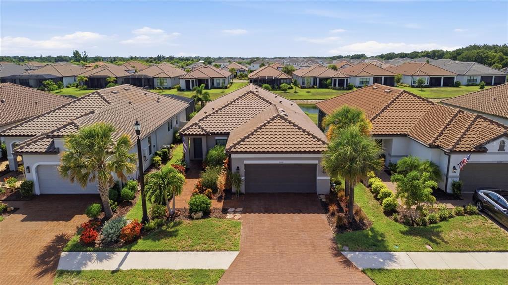 An aerial view of a suburban house with a tiled roof and brick driveway — 11115 DEVONBRIDGE DRIVE, PALMETTO, FL