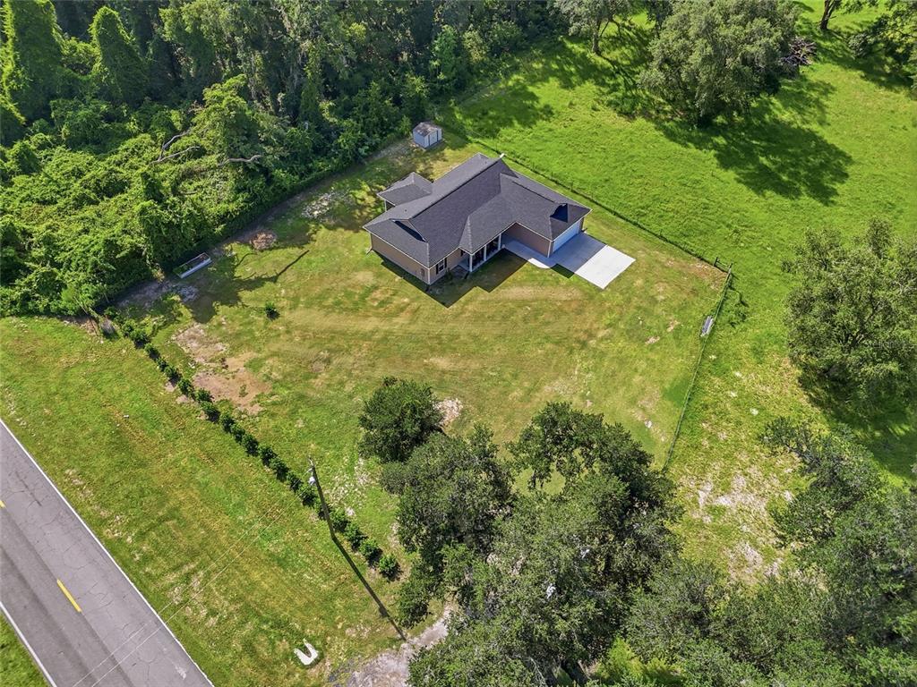 An aerial view shows a single-story house with a dark roof on a grassy lot — 5766 SW COUNTY ROAD 18, FORT WHITE, FL