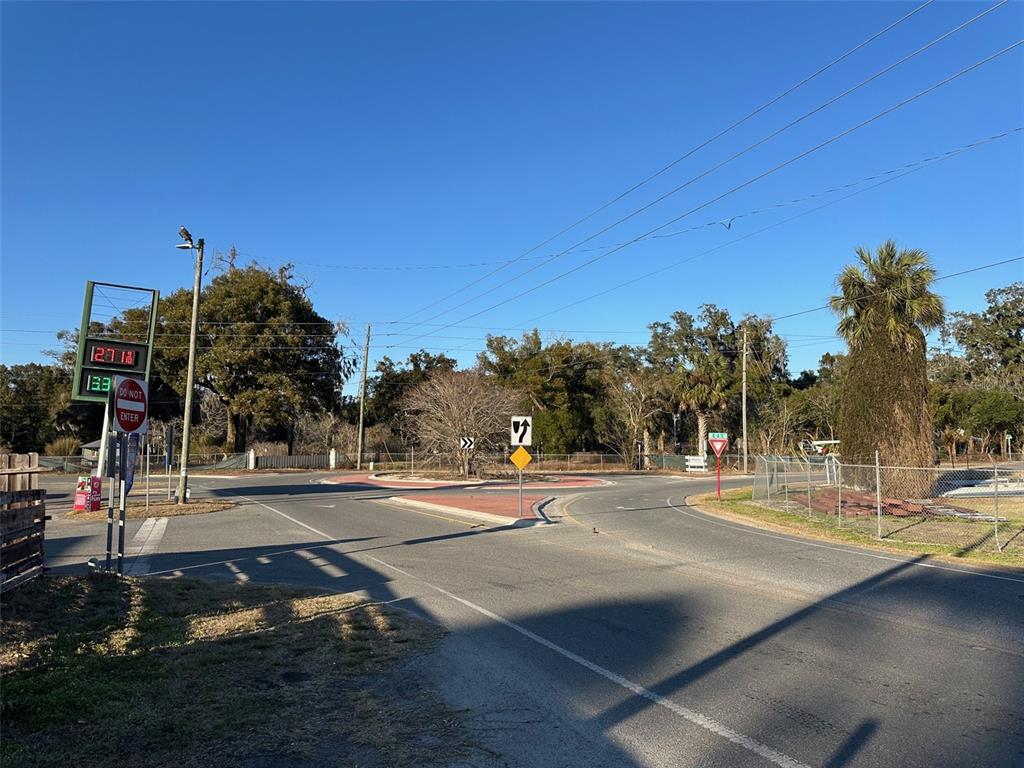 A paved roundabout features a central island with trees and various traffic signs — 9710 NE 21ST AVENUE, ANTHONY, FL