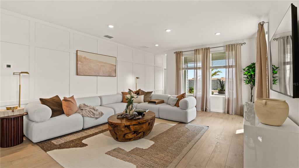 A living room features a white sectional sofa, a wooden coffee table, and paneled walls — 3116 ROCKWOOD WAY, MINNEOLA, FL