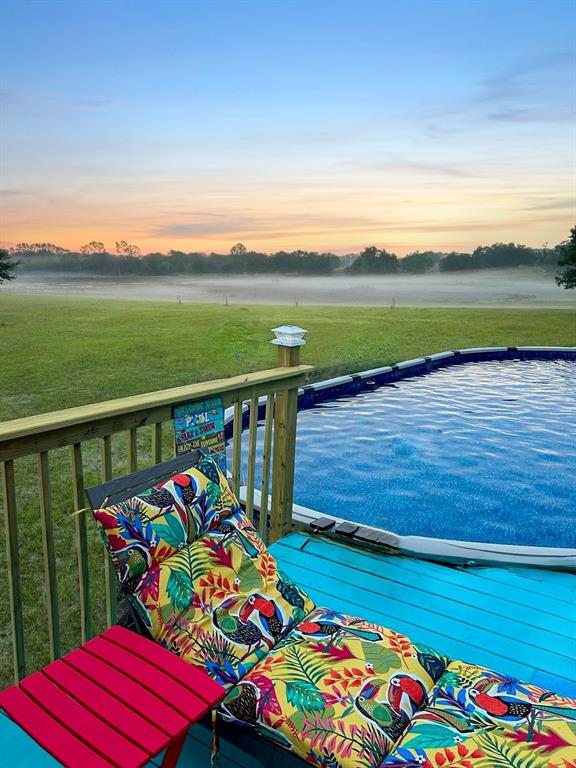 A tan manufactured home with a brick walkway and a large lawn under a blue sky — 12651 SE COUNTY ROAD 337, DUNNELLON, FL