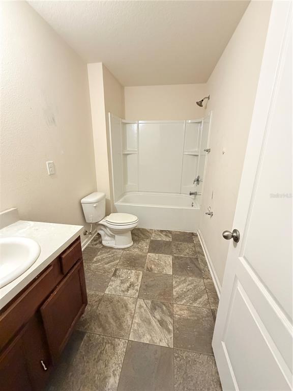 A bathroom features a vanity, a toilet, and a tub-shower combination with tiled flooring — 45170 DUTTON WAY, CALLAHAN, FL