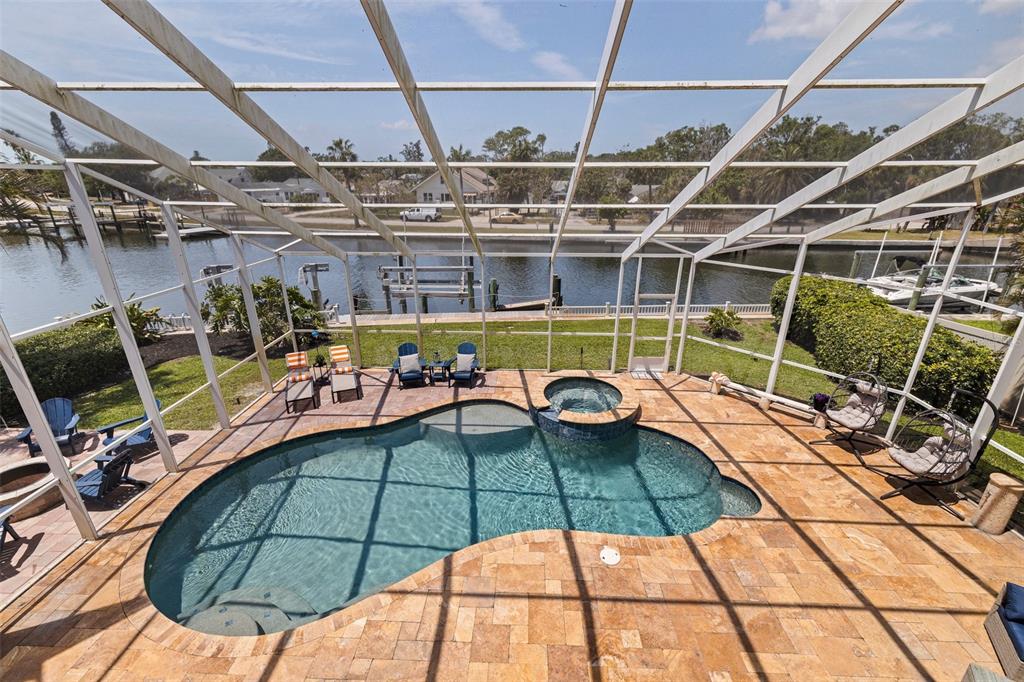 An elevated view of a screened-in pool patio overlooking a canal with a boat dock — 3931 POMPANO DRIVE SE, ST PETERSBURG, FL