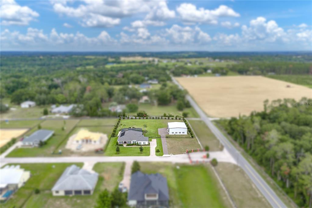 An aerial view shows a house and a detached garage on a grassy lot — 32655 WESLEY WAY, DADE CITY, FL