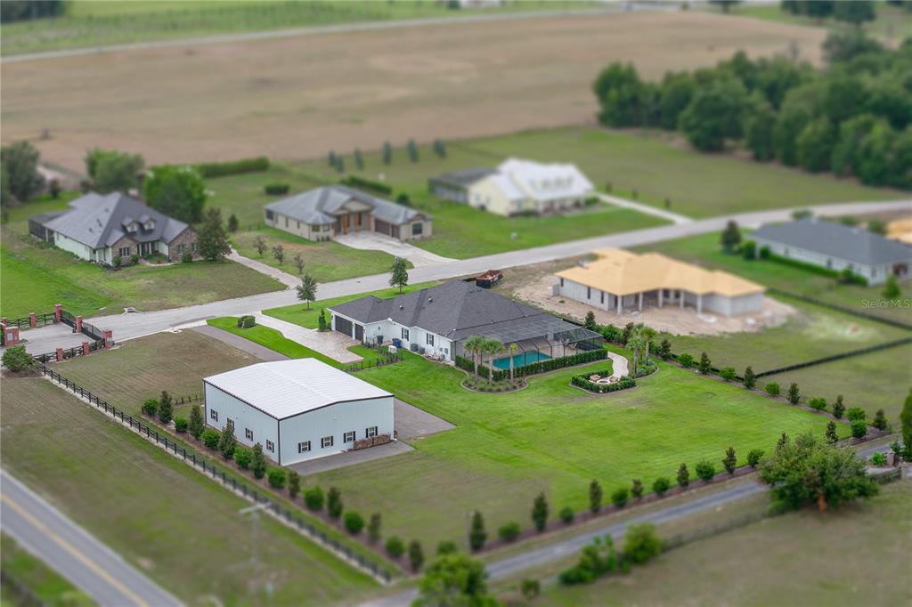 An aerial view shows a residential property with a large house, pool, and detached workshop — 32655 WESLEY WAY, DADE CITY, FL