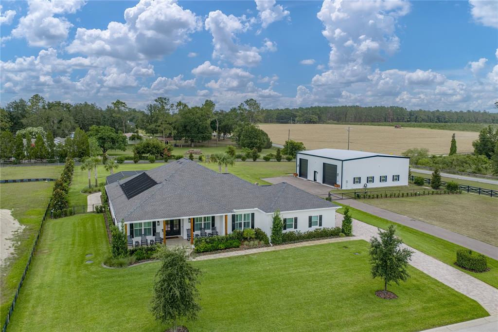An aerial view shows a single-story house with a detached garage and large lawn — 32655 WESLEY WAY, DADE CITY, FL