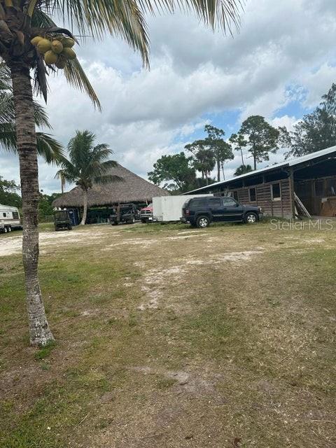 A palm tree stands in the foreground of a rural property with a large barn — 3525 D RD, LOXAHATCHEE GROVES, FL