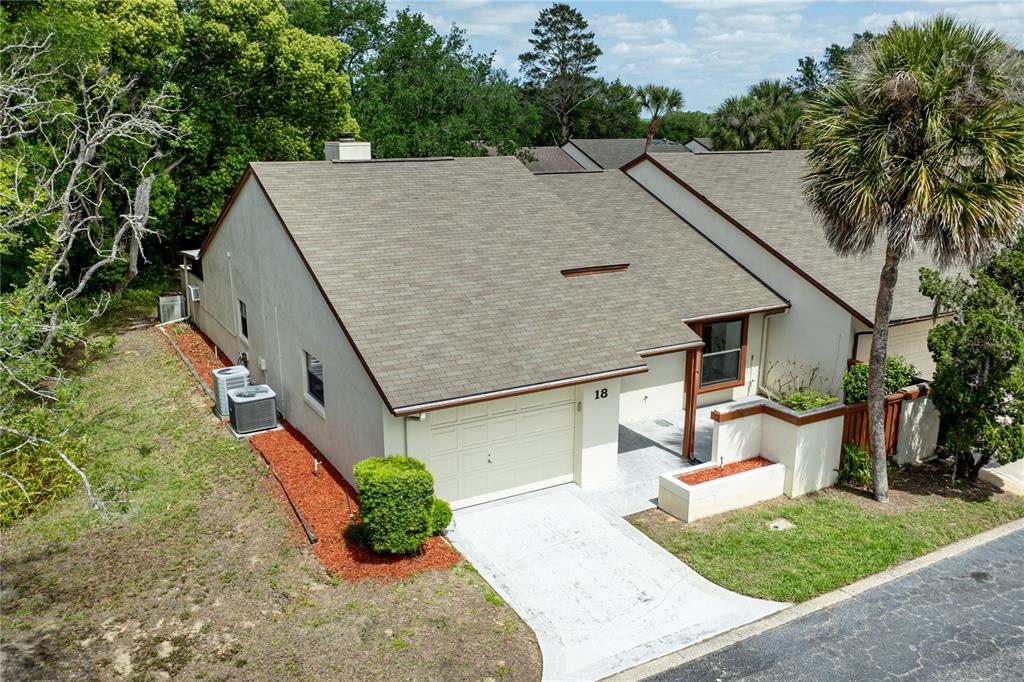 An aerial view of a single-story residential townhouse with a garage and a palm tree — 2681 WASHINGTON AVENUE UNIT 18, EUSTIS, FL