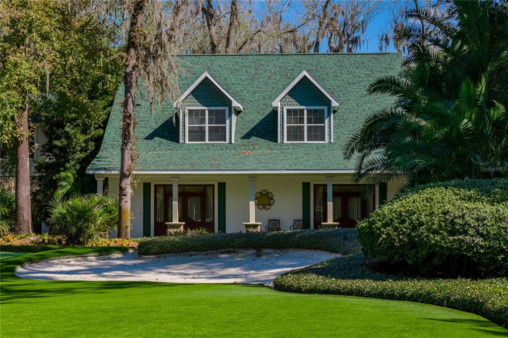 A two-story house with a green shingled roof and dormer windows sits behind a sand trap — 3515 GALLAGHER ROAD, DOVER, FL