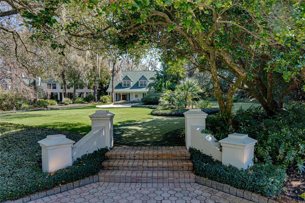 A brick staircase leads from a paved patio to a green lawn and house — 3515 GALLAGHER ROAD, DOVER, FL