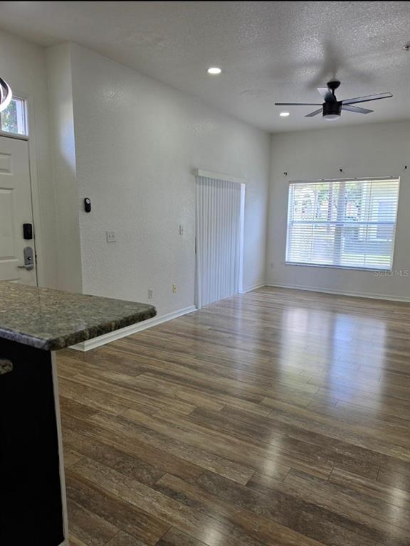 An open-concept living area features wood-look flooring, a ceiling fan, and a sliding glass door — 2260 SAN VITAL DRIVES UNIT 108, KISSIMMEE, FL