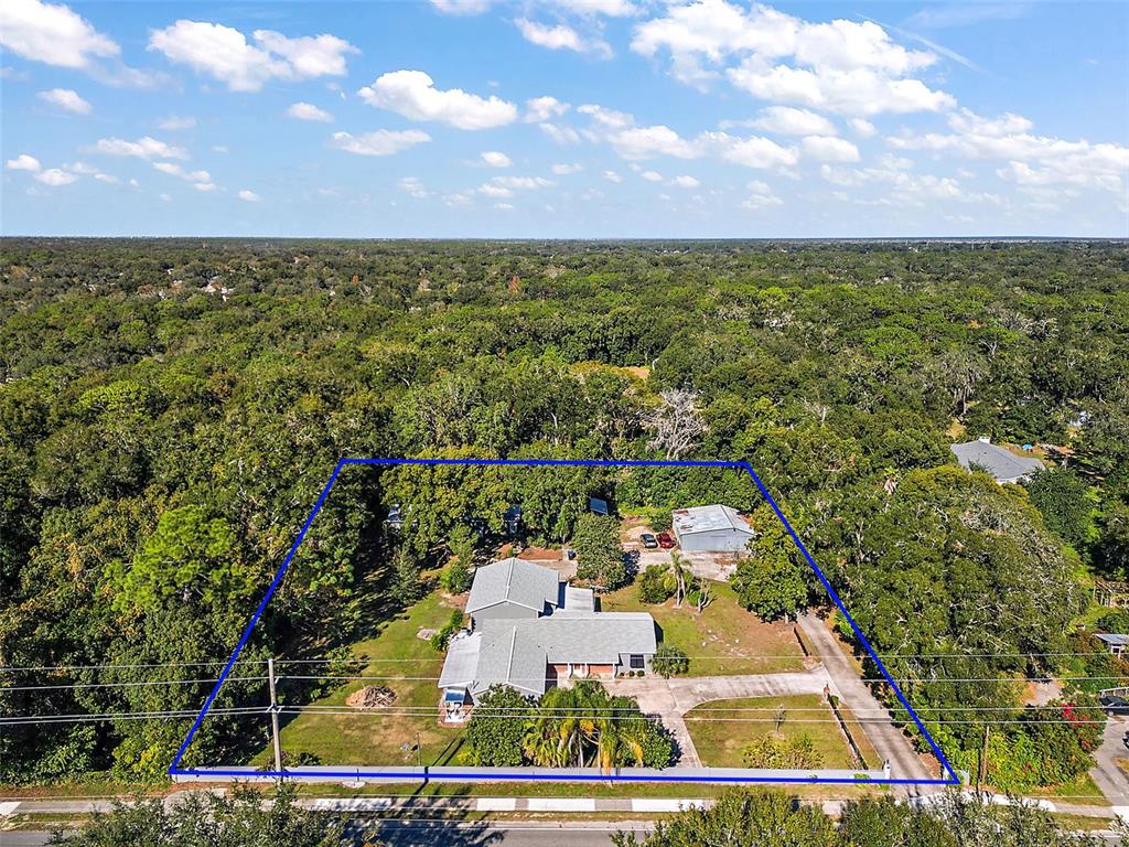 An aerial view shows a house and a detached garage on a wooded lot — 1661 VOTAW ROAD, APOPKA, FL