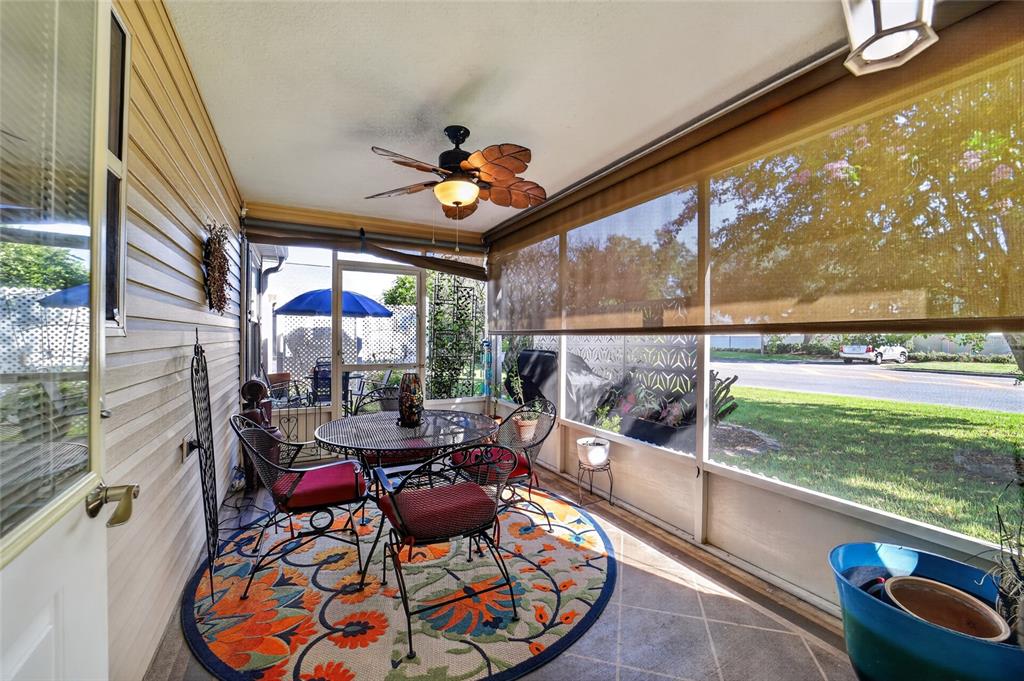 A single-story house with a white garage, a front porch, and a landscaped yard at sunset — 1563 HOLLYBERRY PLACE, THE VILLAGES, FL