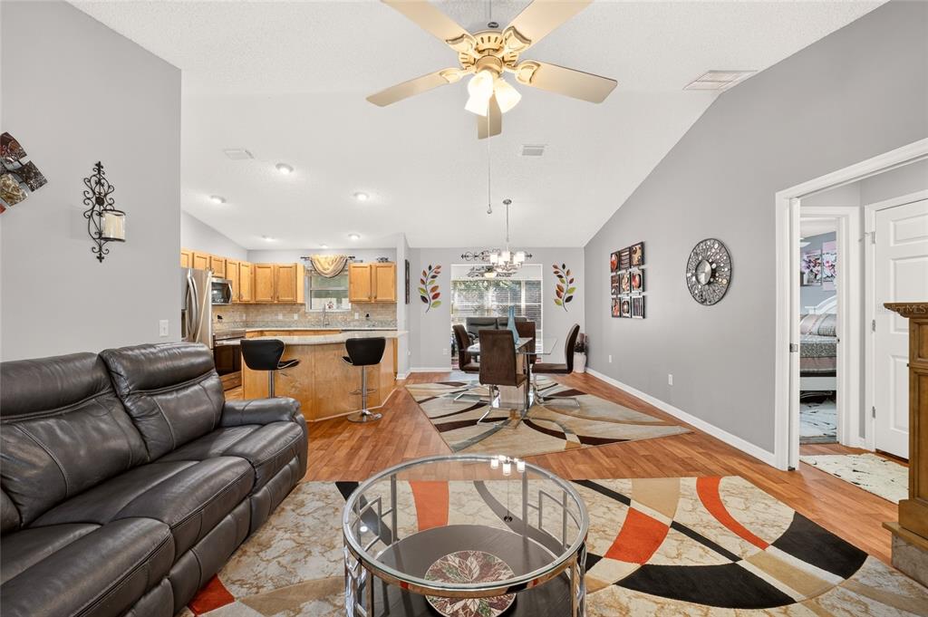 A single-story house with a two-car garage, a screened front porch, and a landscaped lawn — 1563 HOLLYBERRY PLACE, THE VILLAGES, FL