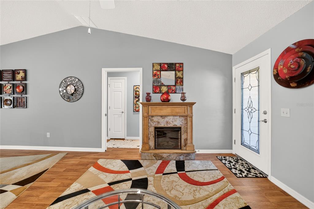 A single-story house with a palm tree in the front yard and red mulch beds — 1563 HOLLYBERRY PLACE, THE VILLAGES, FL