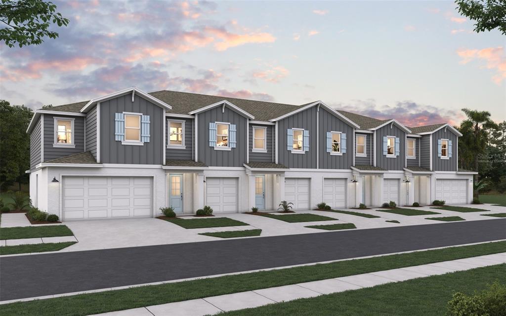 A digital rendering of a row of modern townhomes with gray siding and white garages — 31665 OCEAN BREEZE DRIVE, SAN ANTONIO, FL