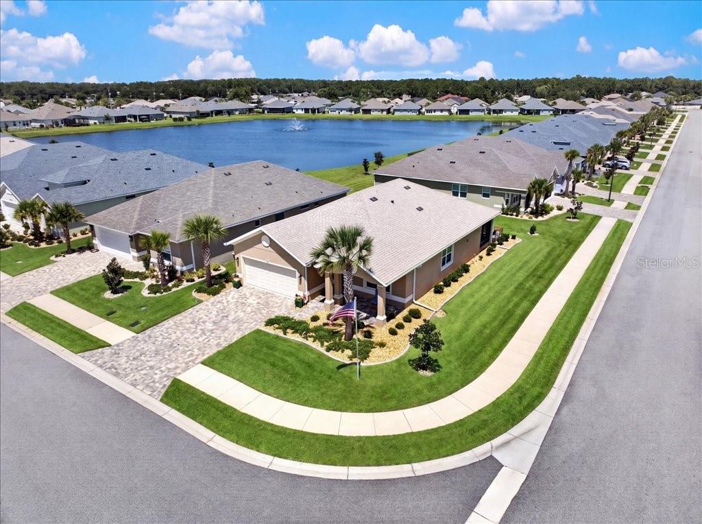 An aerial view shows a suburban house with a paved driveway and lawn near a lake — 2 TIDEWAY TRAIL, PALM COAST, FL