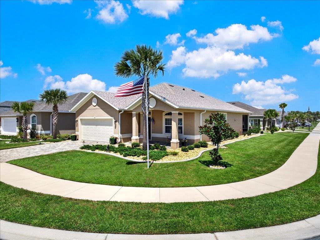 A single-story suburban house with a tan exterior, a two-car garage, and a front lawn — 2 TIDEWAY TRAIL, PALM COAST, FL