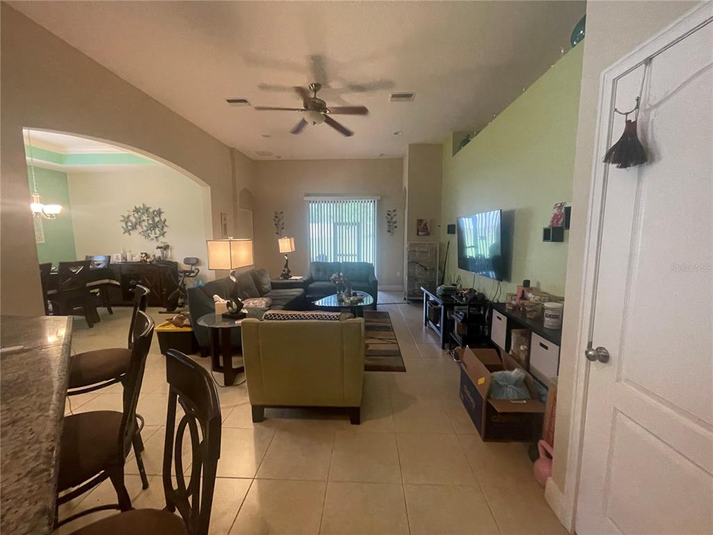 A living room with tile flooring, a ceiling fan, and an adjacent dining area — 824 VINO VERDE CIRCLE, BRANDON, FL