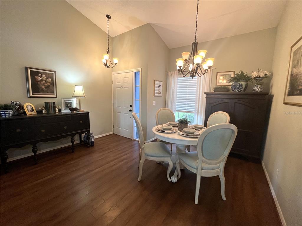 An entryway features wood-look flooring, a white front door with sidelights, and a chandelier — 413 EAGLE RIDGE DRIVE UNIT 413, DAVENPORT, FL
