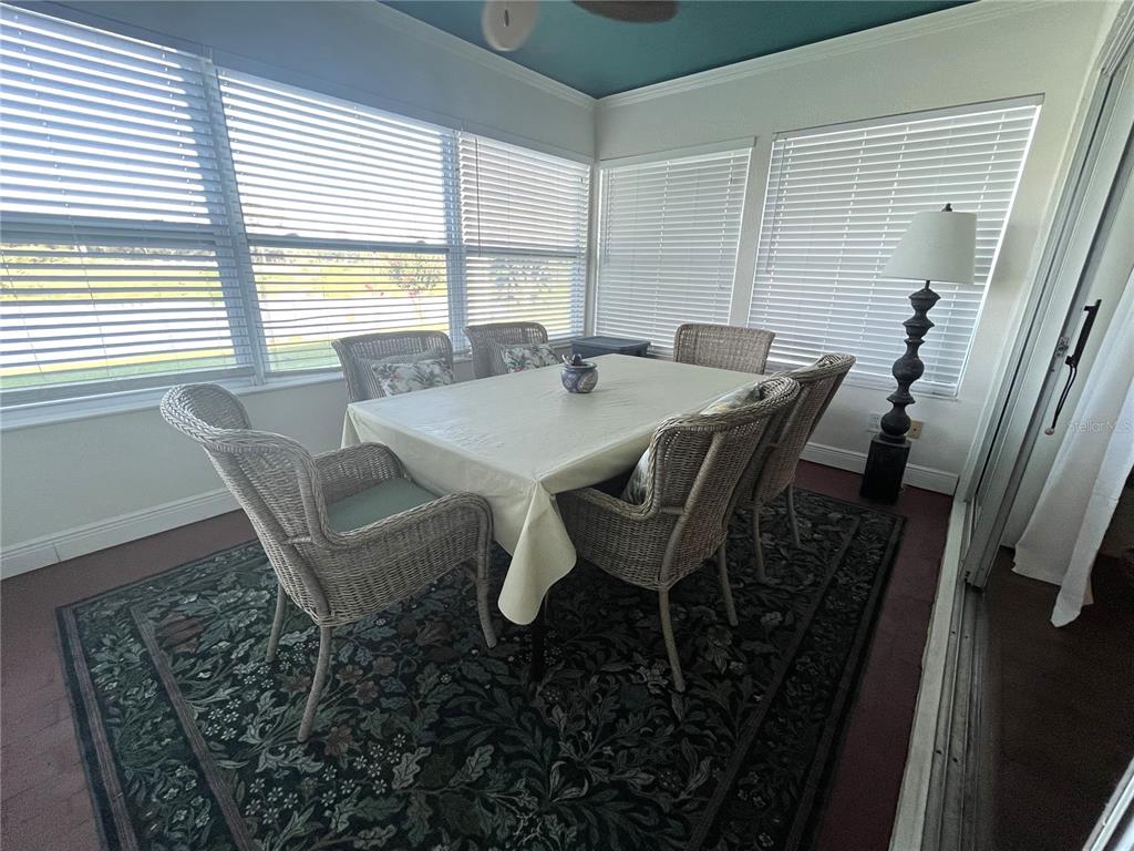 A dining area features a round white table, four upholstered chairs, and a chandelier — 413 EAGLE RIDGE DRIVE UNIT 413, DAVENPORT, FL