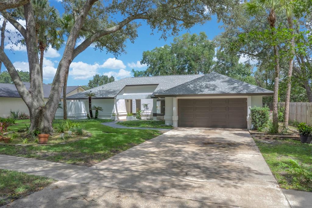A single-story house with a brown garage door, white exterior, and a large front yard — 381 HAVERLAKE CIRCLE, APOPKA, FL