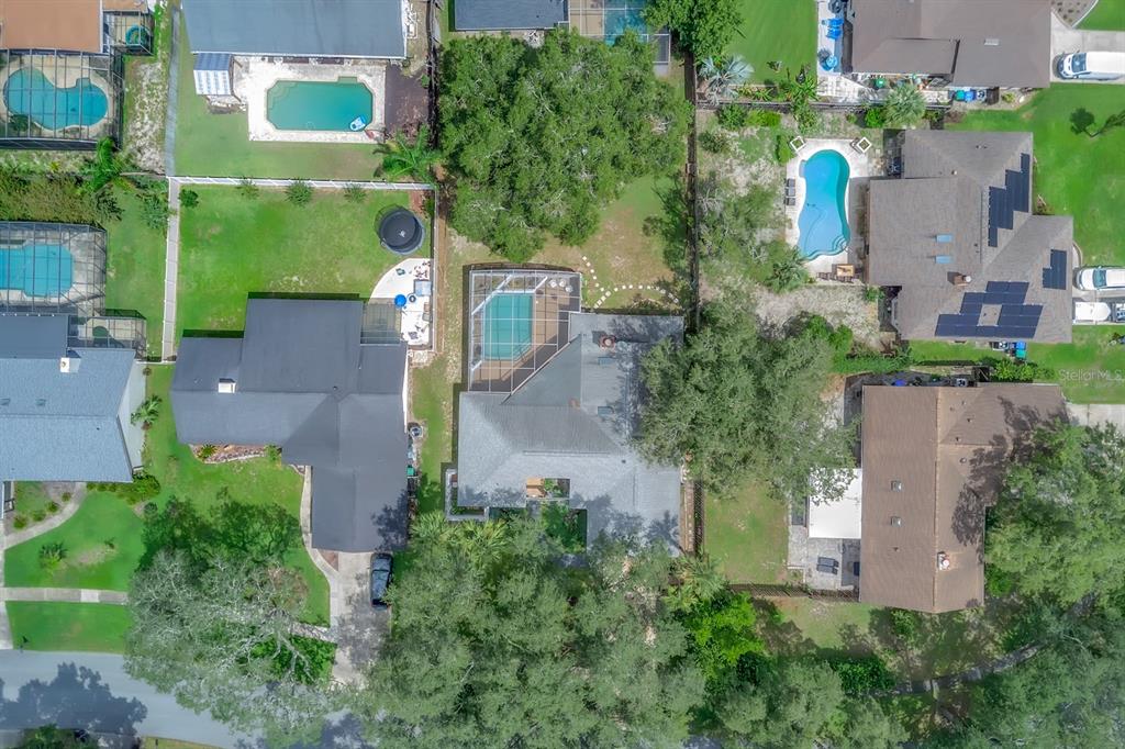An aerial view shows several suburban houses with swimming pools and backyards surrounded by trees — 381 HAVERLAKE CIRCLE, APOPKA, FL