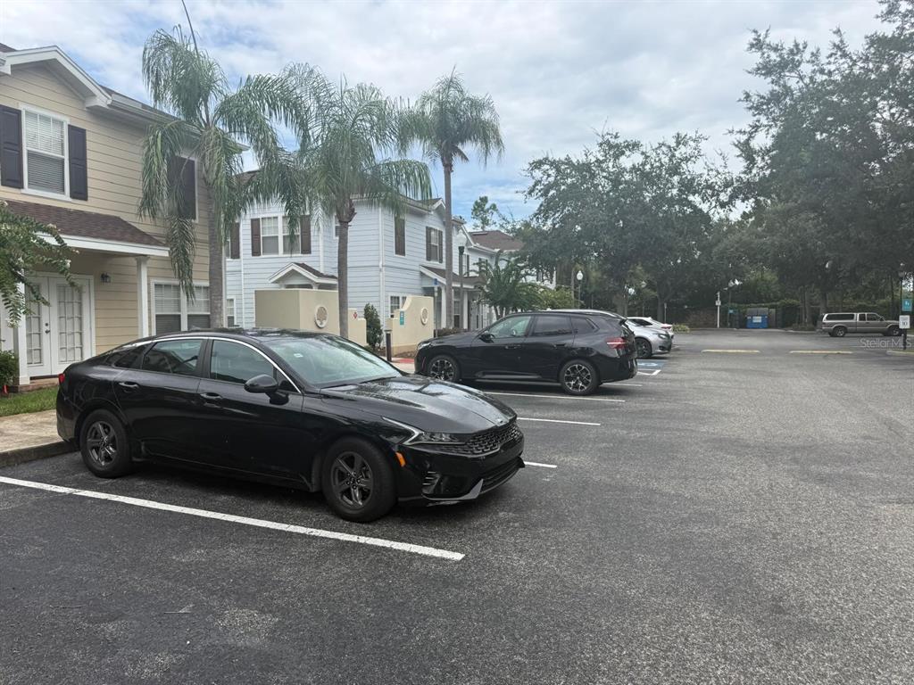 A black sedan is parked in a paved lot in front of two-story residential buildings — 2952 LUCAYAN HARBOUR CIRCLE UNIT 103, KISSIMMEE, FL
