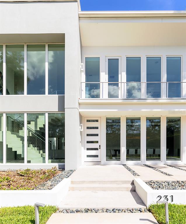 A modern two-story house features a white facade, large glass windows, and a front entrance — 231 CHELTON CIRCLE, WINTER PARK, FL