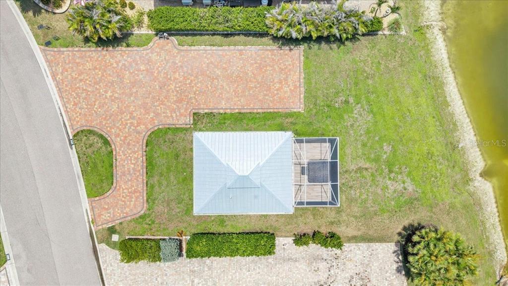 An aerial view shows a house with a screened-in patio, large driveway, and grassy yard — 8168 SW SAND CRANE CIRCLE, ARCADIA, FL