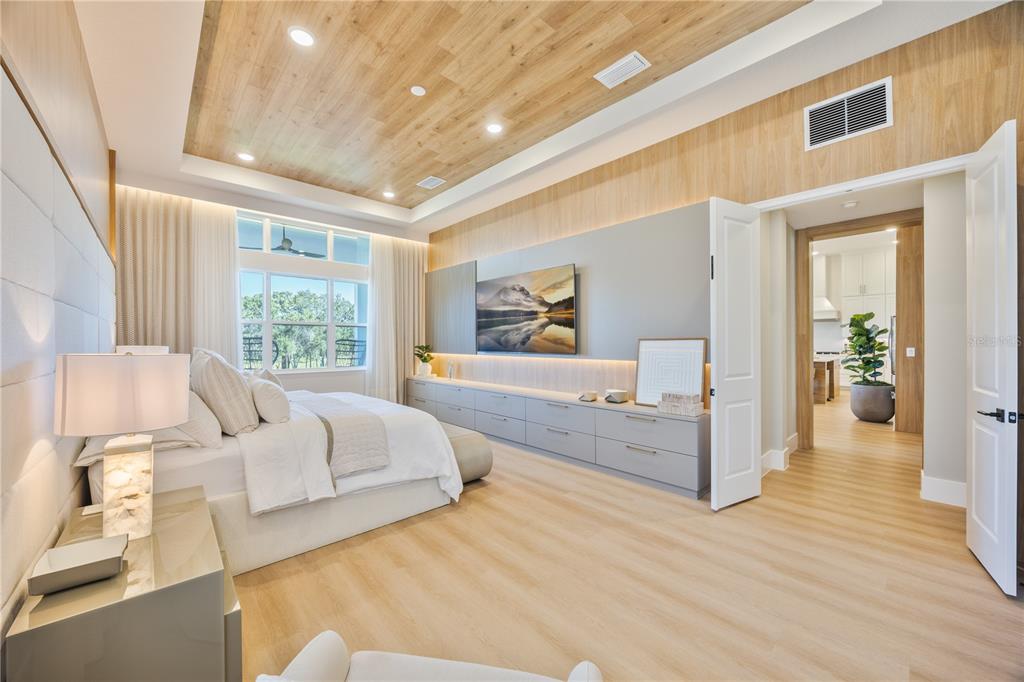 A modern living room features a curved white sofa, two armchairs, and a gold chandelier — 16077 BARKLY RIDGE COURT, WINTER GARDEN, FL