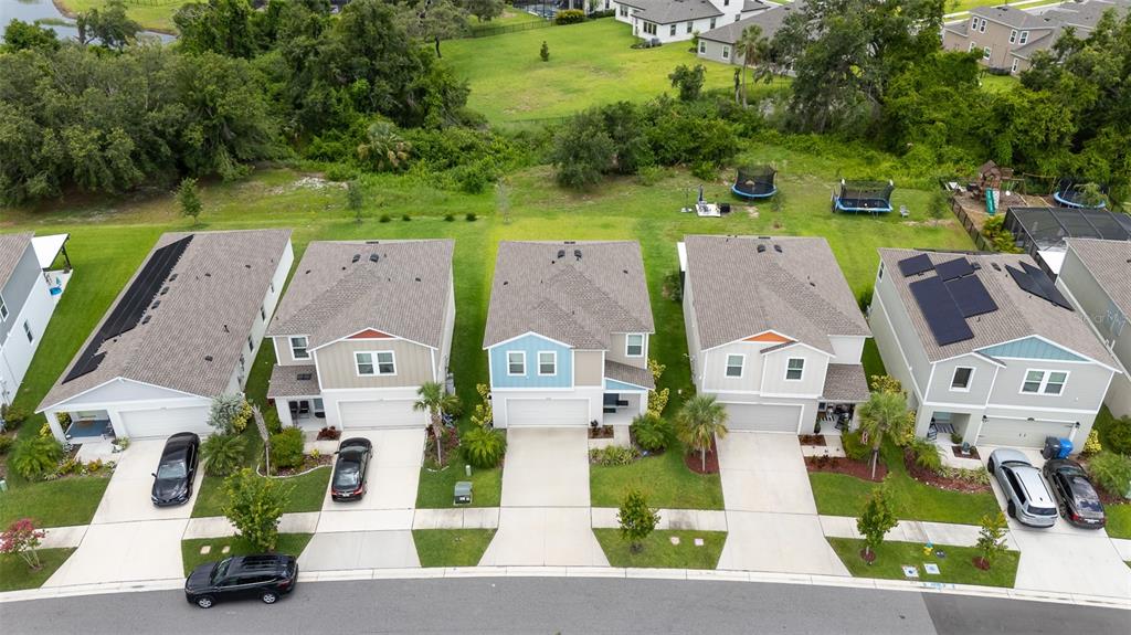 An aerial view shows a row of suburban houses with driveways and backyards — 5528 SUMMER SUNSET DRIVE, APOLLO BEACH, FL