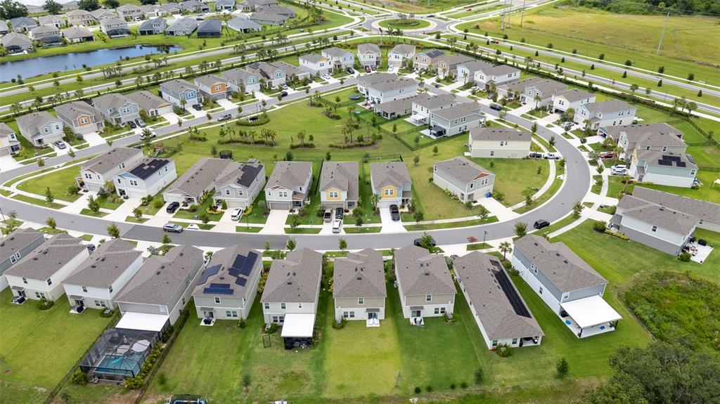 An aerial view shows a suburban neighborhood with many detached houses and a central park — 5528 SUMMER SUNSET DRIVE, APOLLO BEACH, FL