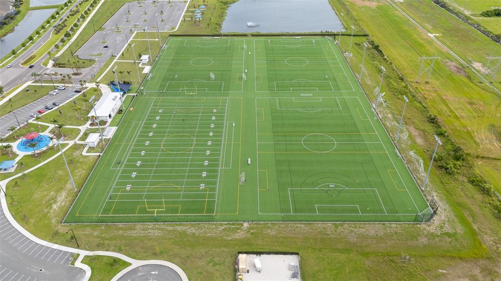 An aerial view shows a large sports complex with multiple turf fields and parking areas — 5528 SUMMER SUNSET DRIVE, APOLLO BEACH, FL