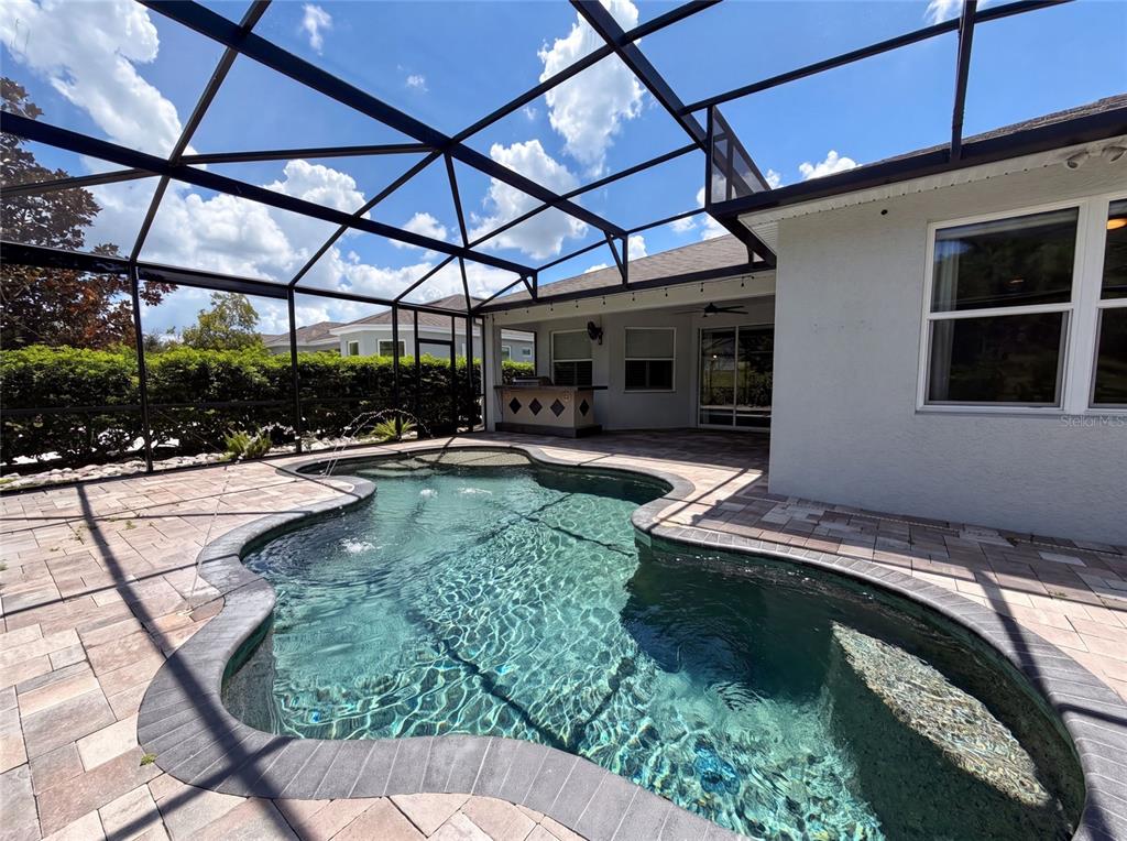 A screened-in patio features a freeform swimming pool and an outdoor bar area — 1011 VICTORIA HILLS DRIVE S, DELAND, FL