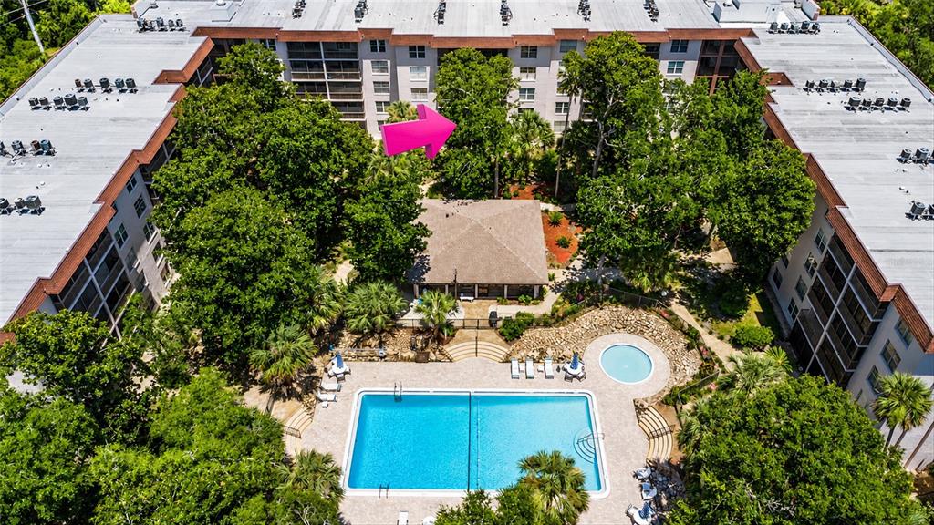 An aerial view of a multi-story apartment complex with a central pool and clubhouse — 640 N NOVA ROAD UNIT 209, ORMOND BEACH, FL