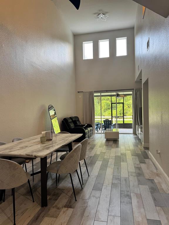 A dining area with a marble table leads into a living room with high ceilings — 1609 CROYDON STREET, ORLANDO, FL